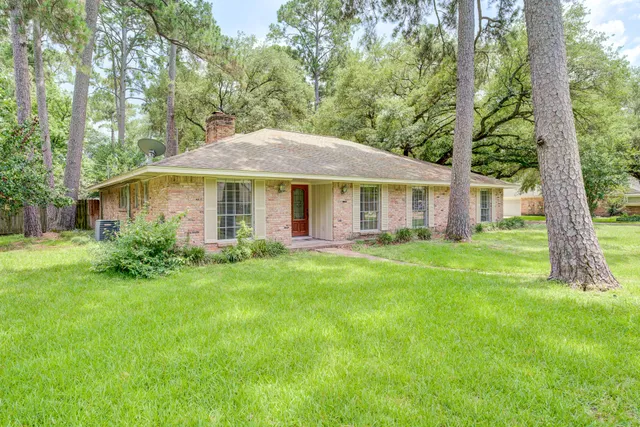 a front view of a house with a yard and trees