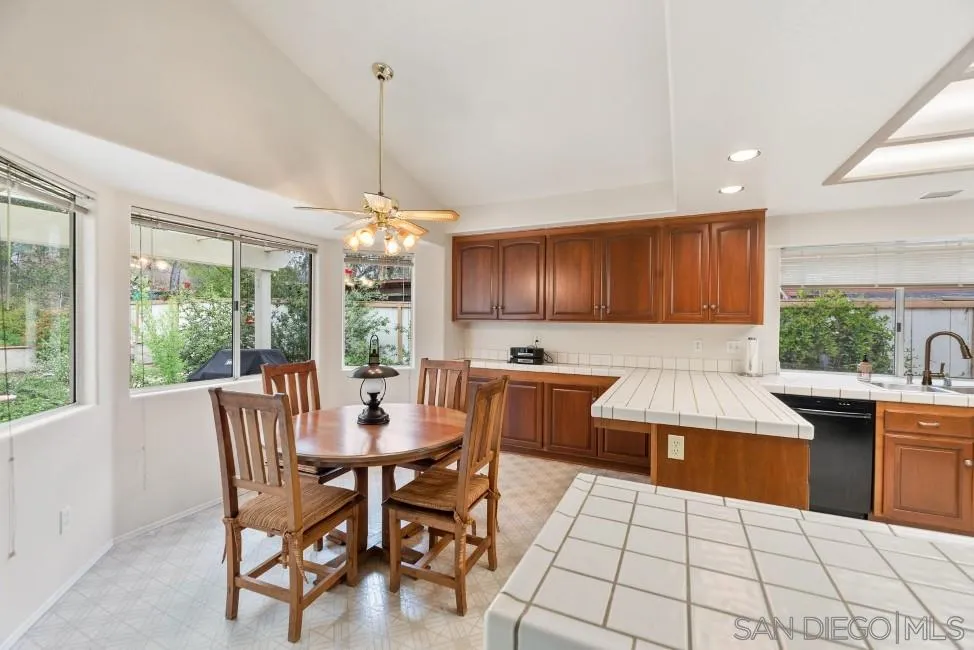 13873 Carriage Road Poway, CA 92064 - Photo 11 of 32 a kitchen with stainless steel appliances kitchen island granite countertop a table chairs and a wooden cabinets