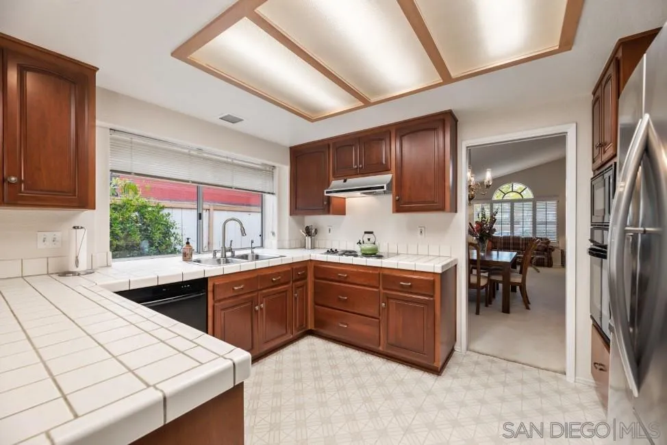 13873 Carriage Road Poway, CA 92064 - Photo 10 of 32 a kitchen with stainless steel appliances kitchen island granite countertop a sink counter space and cabinets