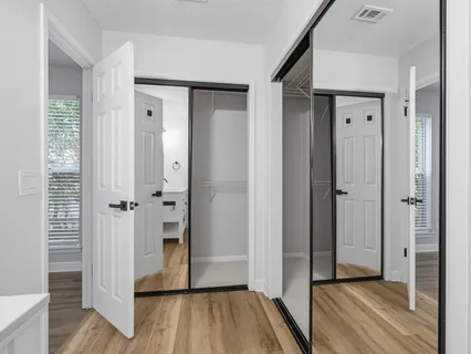 an empty room with wooden floor cabinet and windows
