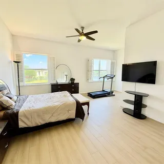 a bedroom with a bed window and a flat screen tv