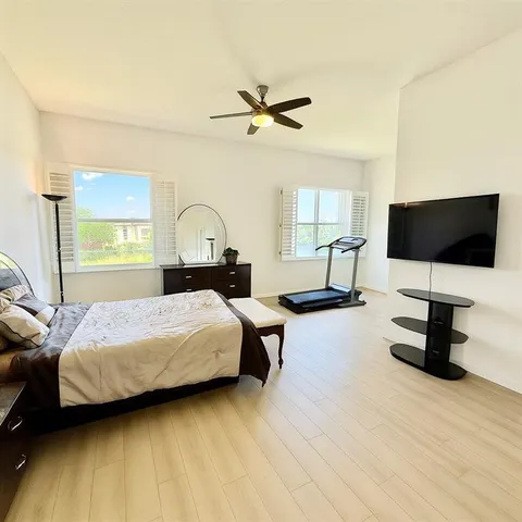 a bedroom with a bed window and a flat screen tv