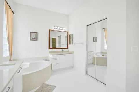 a bathroom with a tub sink and mirror