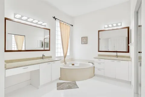 a bathroom with a tub a sink and mirror