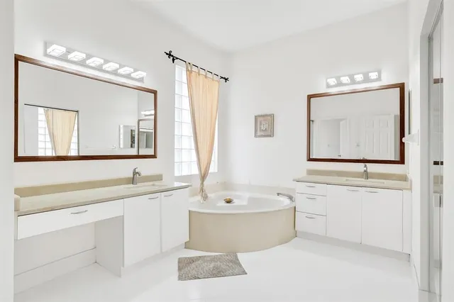 a bathroom with a tub a sink and mirror