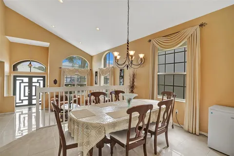 a view of a a dining room with furniture and chandelier
