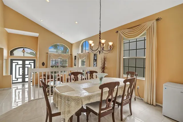 a view of a a dining room with furniture and chandelier