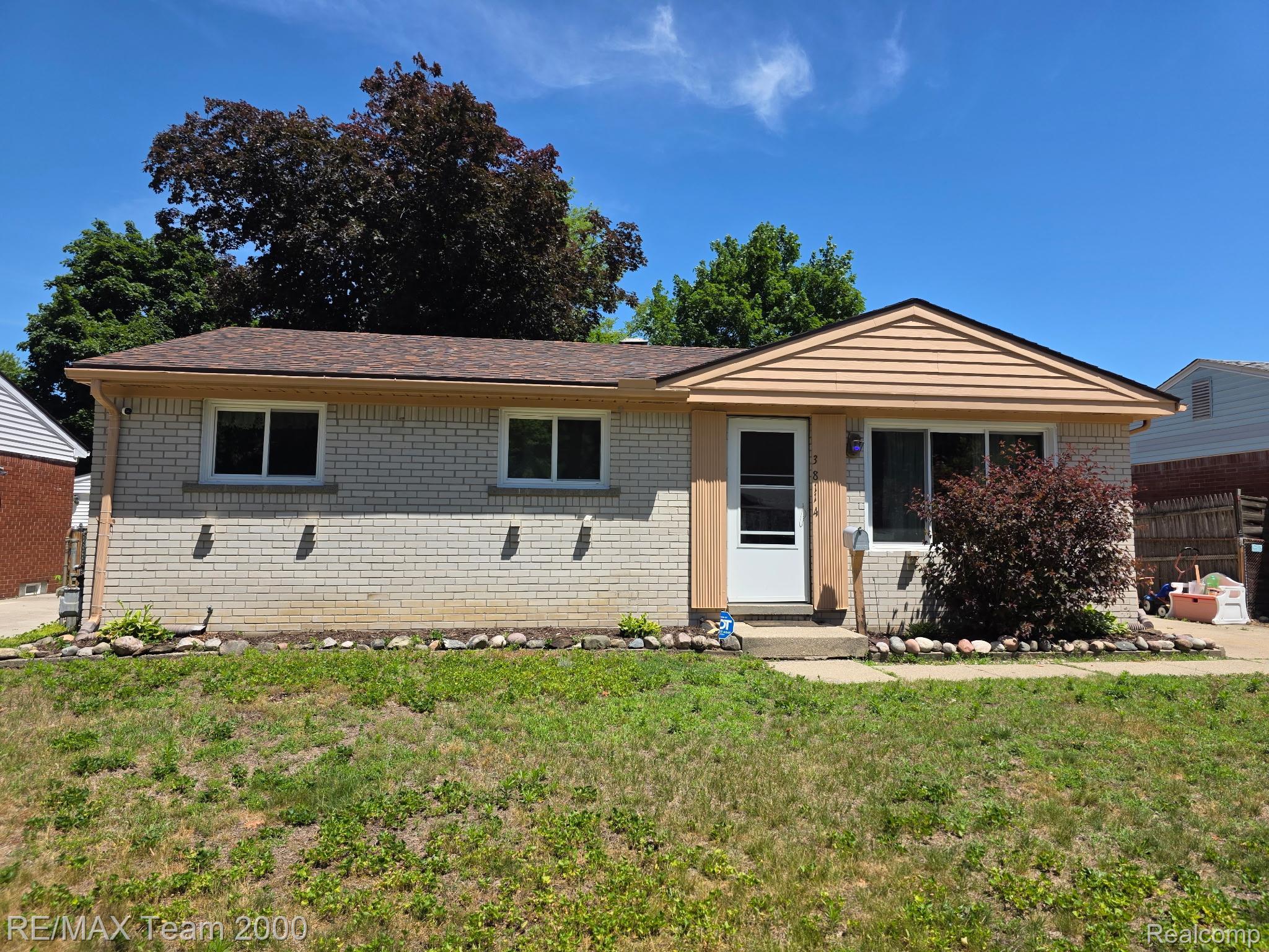 38114 Walnut Street Romulus, MI 48174 - Photo 1 of 18 Ranch-style residence featuring a brick facade with a neutral color palette, a brown shingle roof, and a front entry with a storm door