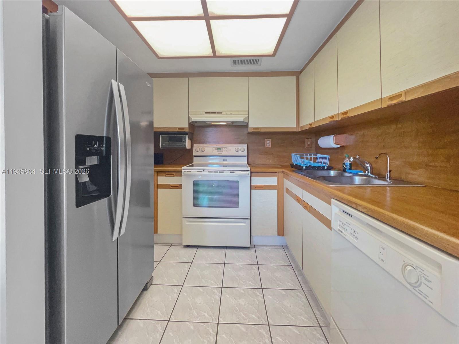 9255 Southwest 125th Avenue, Unit R308 Miami, FL 33186 - Photo 4 of 19 a kitchen with stainless steel appliances a refrigerator sink and cabinets