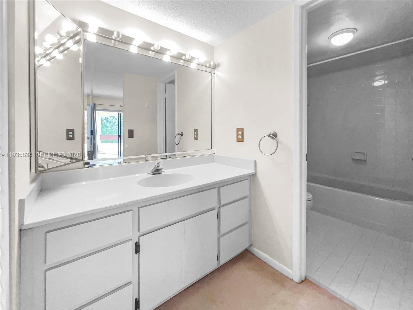 9255 Southwest 125th Avenue, Unit R308 Miami, FL 33186 - Photo 6 of 19 a bathroom with a double vanity sink mirror and shower