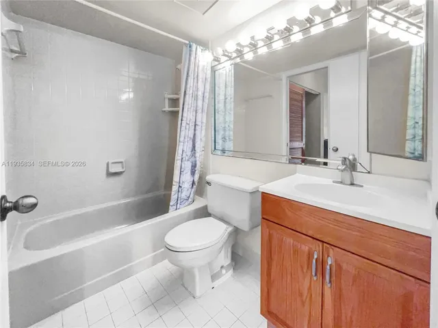 a bathroom with a sink a toilet a mirror a bathtub and shower