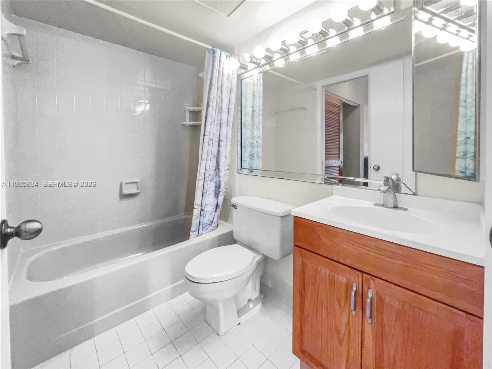 9255 Southwest 125th Avenue, Unit R308 Miami, FL 33186 - Photo 8 of 19 a bathroom with a sink a toilet a mirror a bathtub and shower