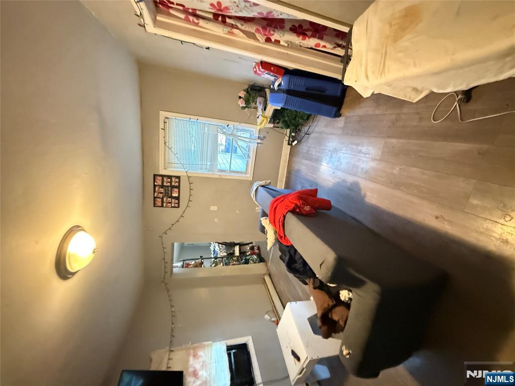 63 Pearl Street Paterson, NJ 07501 - Photo 9 of 16 a bedroom with a bed and wooden floor