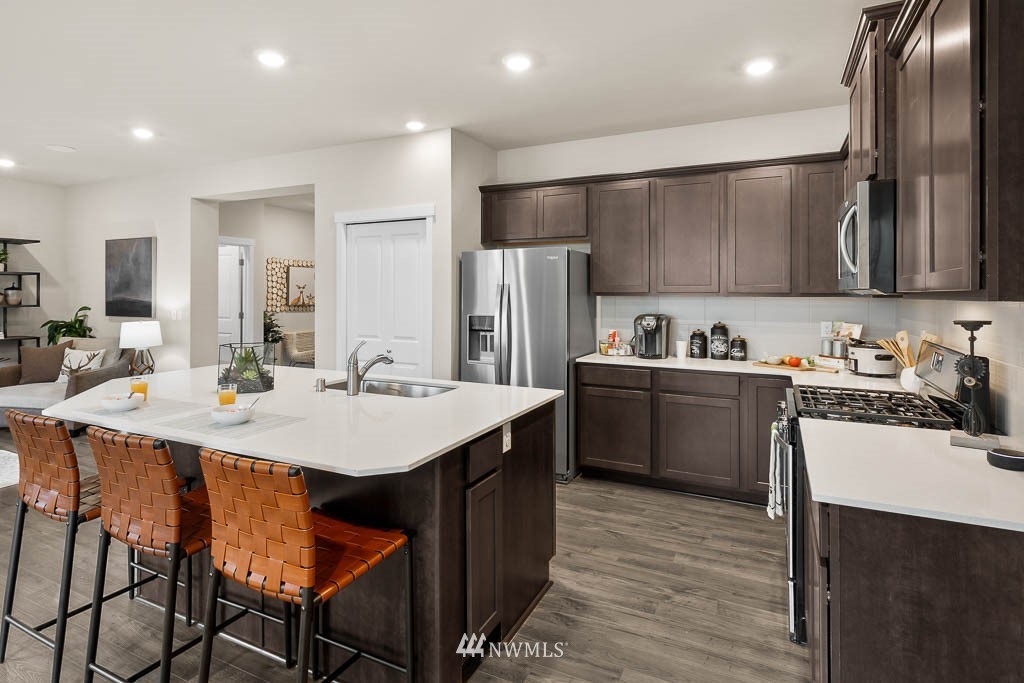 21126 Meridian Drive Southeast, Unit P2 Bothell, WA 98021 - Photo 4 of 29 a kitchen with a sink a refrigerator and chairs