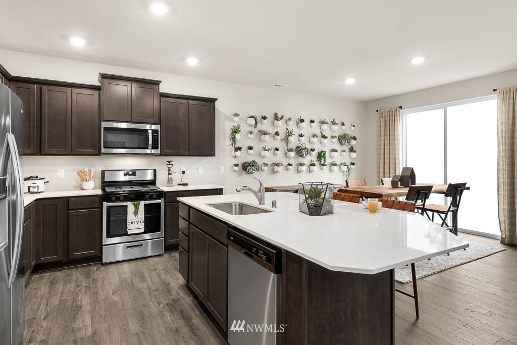 21126 Meridian Drive Southeast, Unit P2 Bothell, WA 98021 - Photo 5 of 29 a kitchen with stainless steel appliances a stove a sink a microwave a refrigerator and island