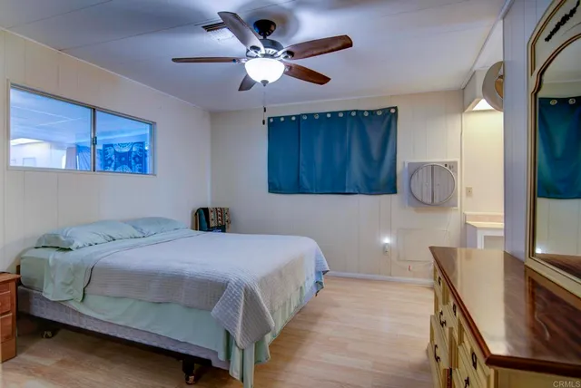 a bedroom with a bed a chandelier and dresser