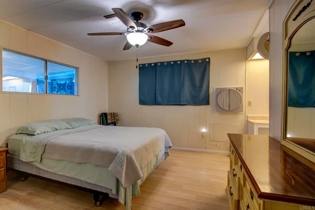 a bedroom with a bed a window and a chandelier