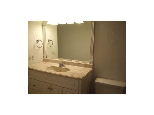 a bathroom with a sink a mirror and a vanity