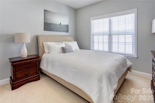 a large bed sitting in a bedroom next to a window