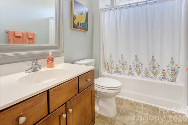 a bathroom with a sink a toilet and a shower curtain