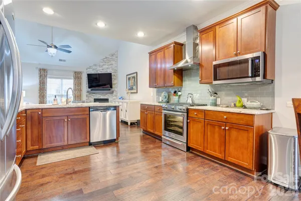a large kitchen with stainless steel appliances sink a microwave and cabinets