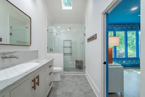 a bathroom with a granite countertop sink and a mirror