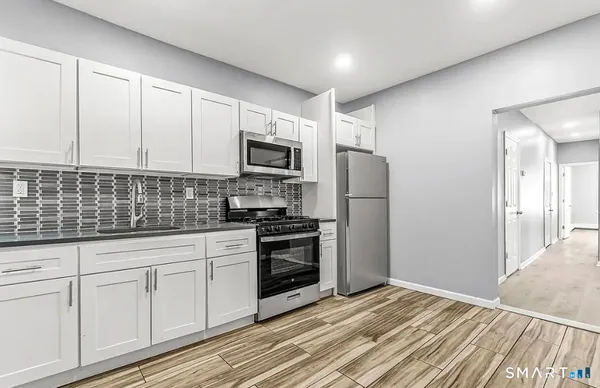 a kitchen with white cabinets stainless steel appliances and sink