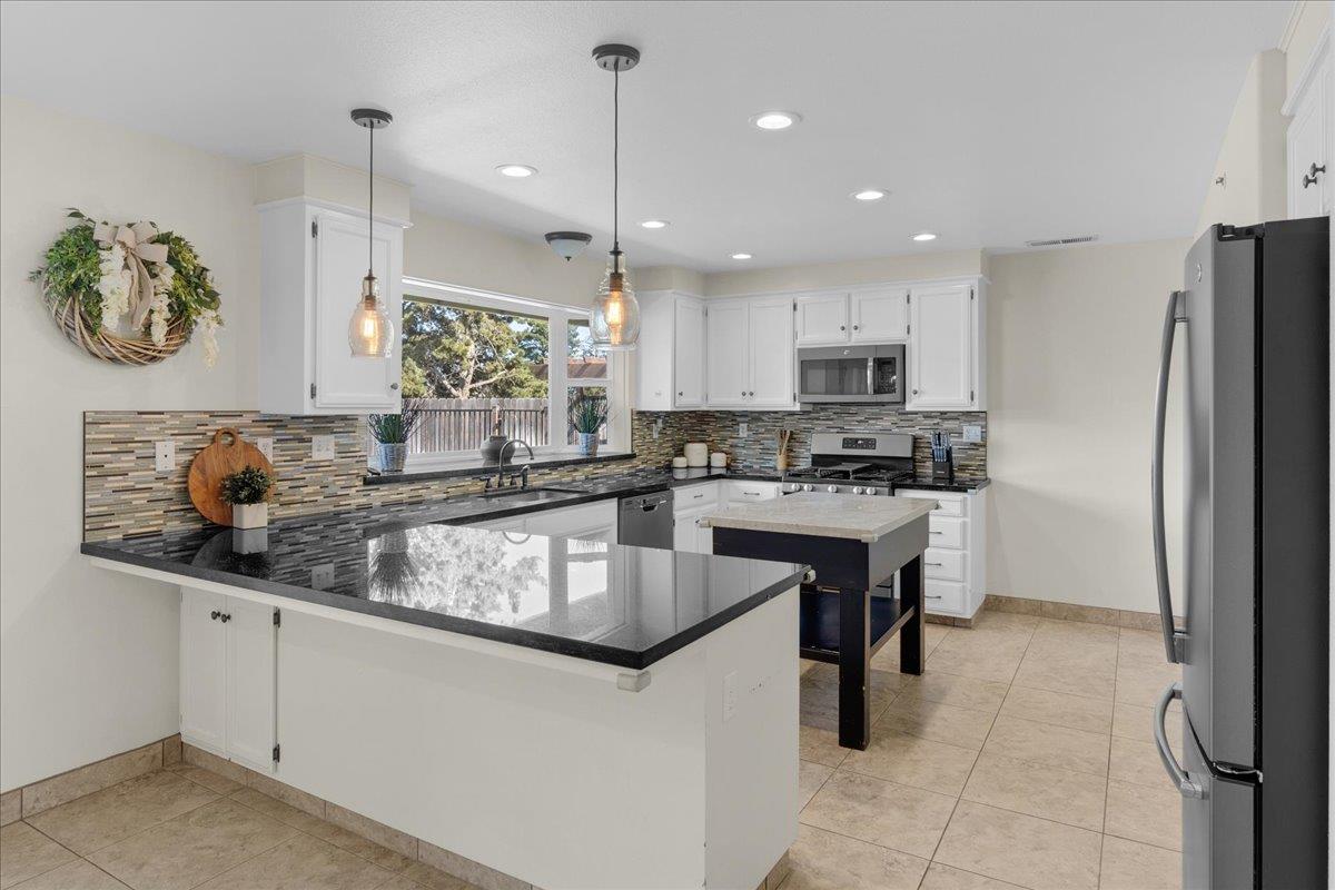 18595 Ranchito Del Rio Drive Salinas, CA 93908 - Photo 12 of 40 a kitchen with kitchen island granite countertop a sink a counter top space appliances and cabinets
