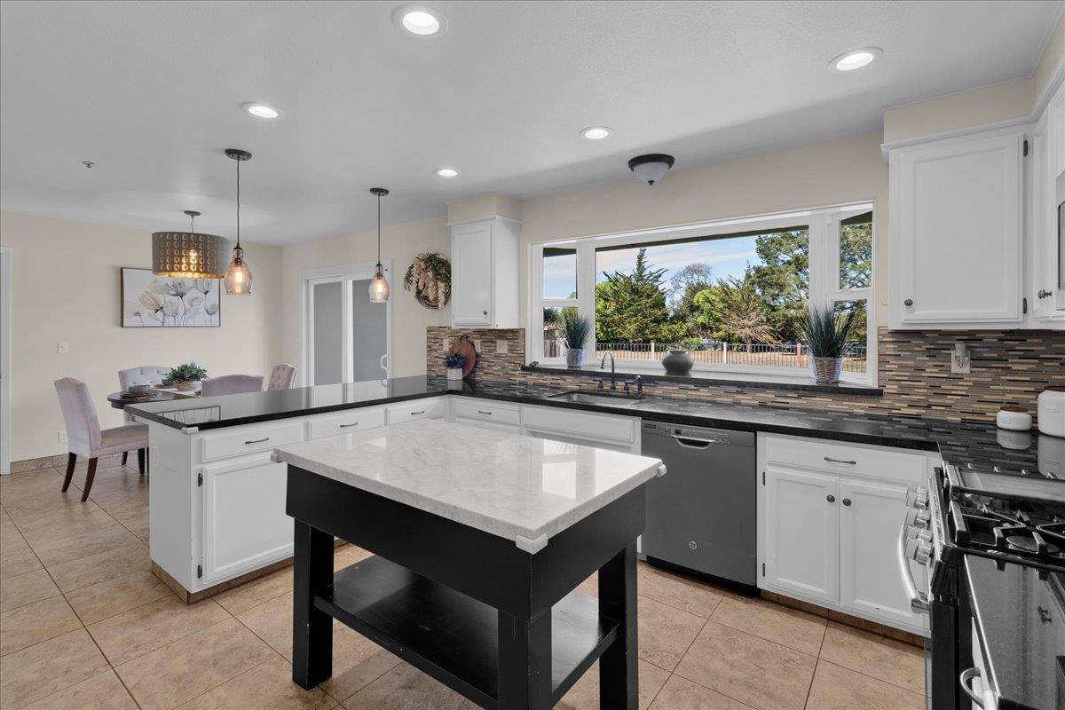 18595 Ranchito Del Rio Drive Salinas, CA 93908 - Photo 13 of 40 a kitchen with center island table and chairs in it