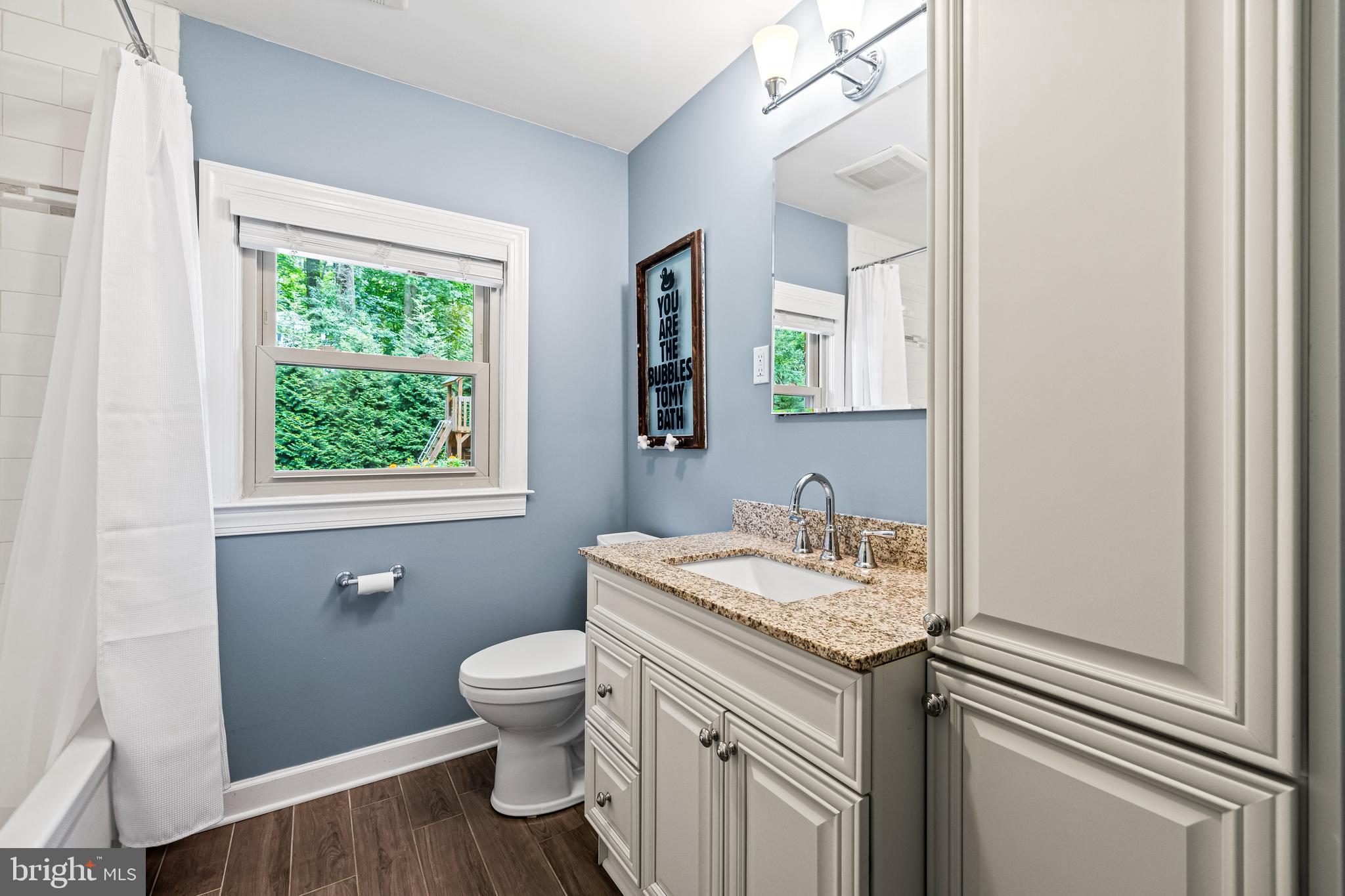 5507 Williams Road Hydes, MD 21082 - Photo 23 of 39 a bathroom with a granite countertop sink toilet a mirror and a window