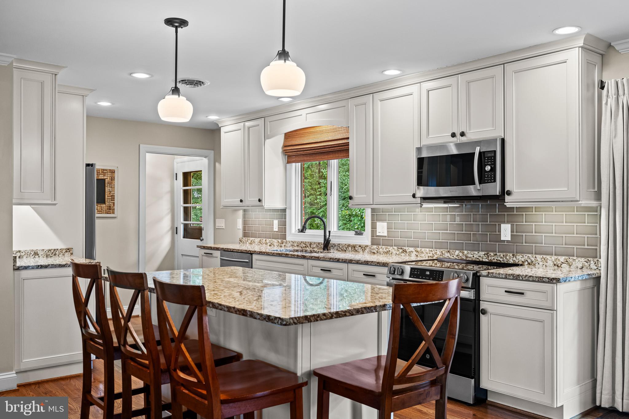 5507 Williams Road Hydes, MD 21082 - Photo 3 of 39 a kitchen with granite countertop a table chairs microwave and sink
