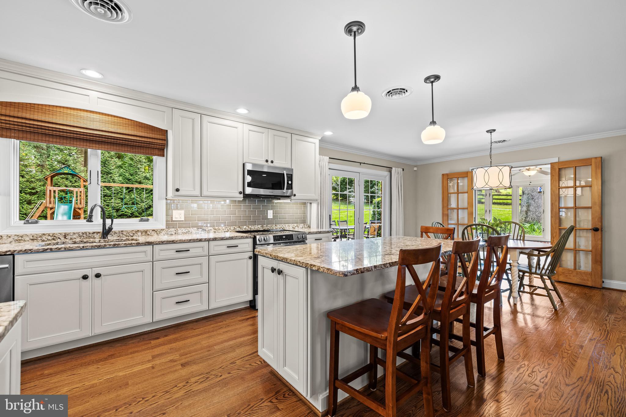 5507 Williams Road Hydes, MD 21082 - Photo 4 of 39 a kitchen with stainless steel appliances granite countertop wooden floor sink stove dining table and chairs