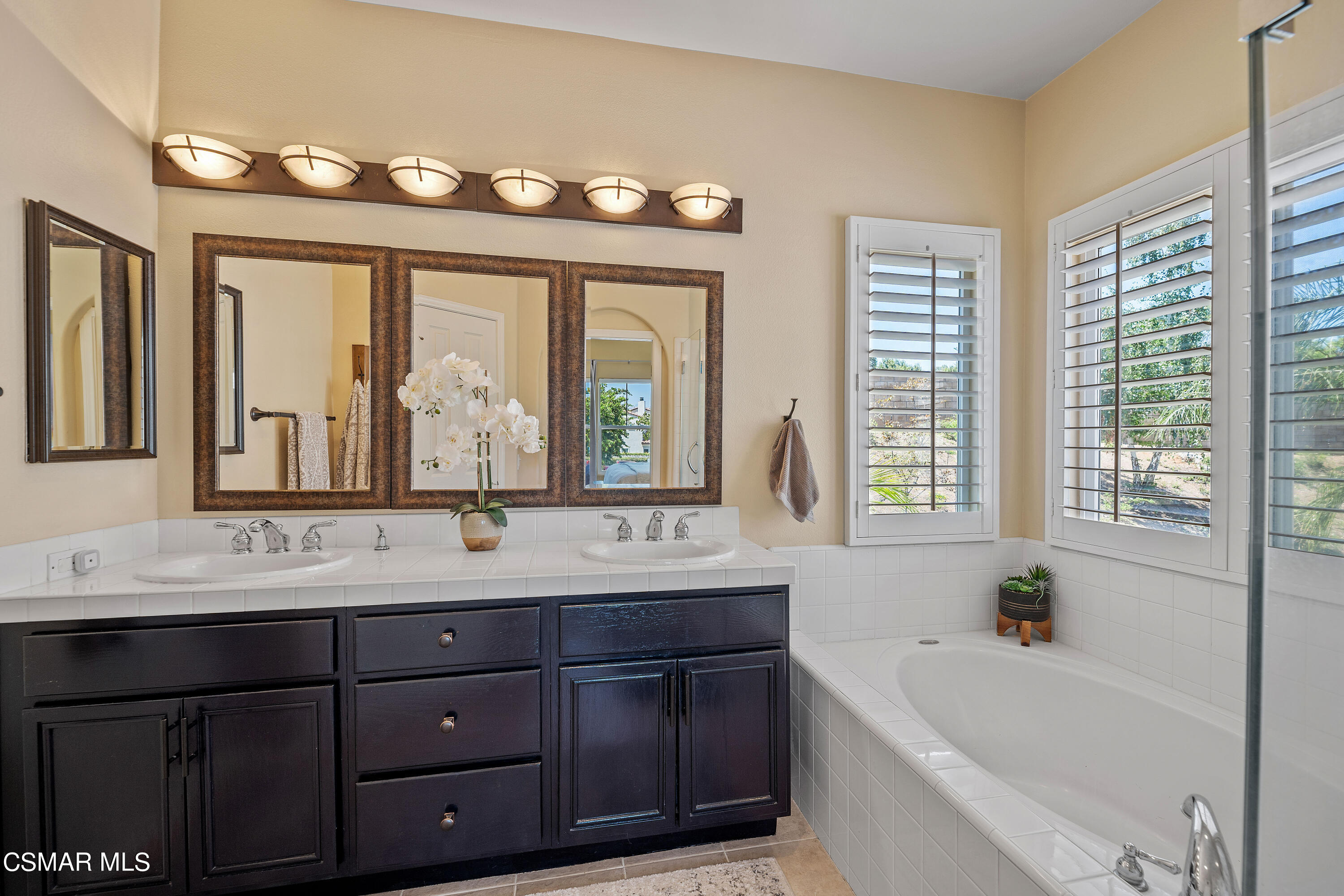 3902 Sarno Court Moorpark, CA 93021 - Photo 22 of 46 a bathroom with double vanity sinks a large mirror and a bathtub