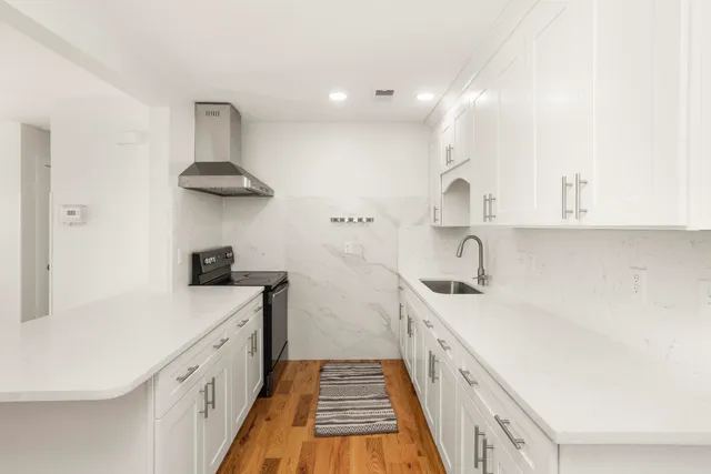 a kitchen with a sink a stove and cabinets