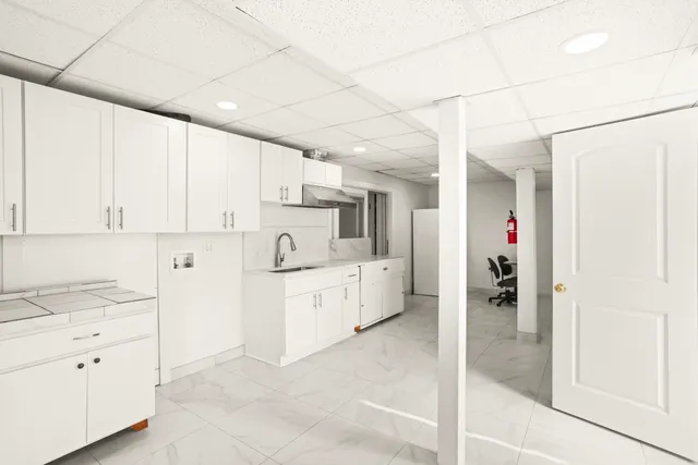 a kitchen with white cabinets and white appliances