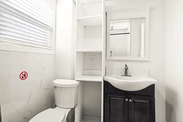 a bathroom with a sink toilet vanity and mirror