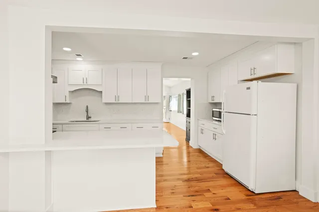 a kitchen with stainless steel appliances a refrigerator sink and white cabinets