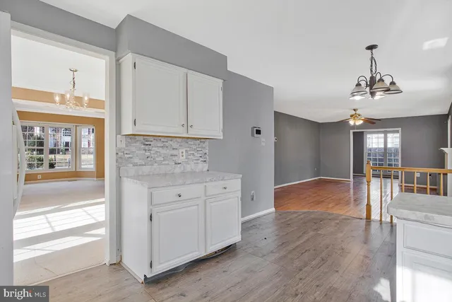 a view of a kitchen with wooden floor cabinets and a ceiling fan