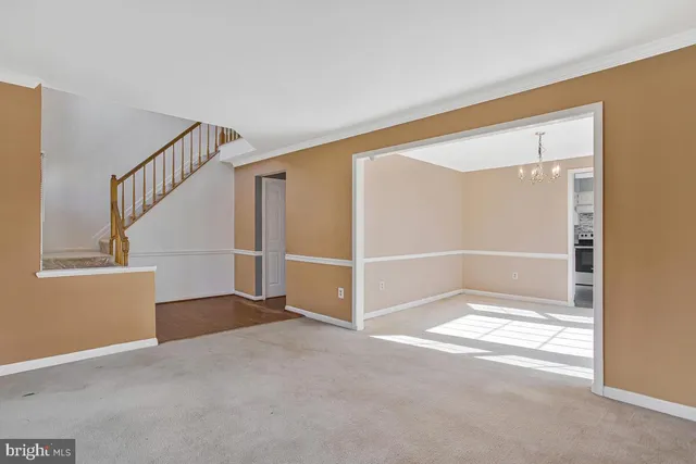 a view of an empty room with wooden floor and windows