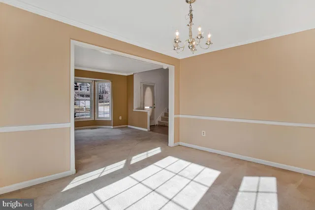 a view of a hallway with windows and chandelier