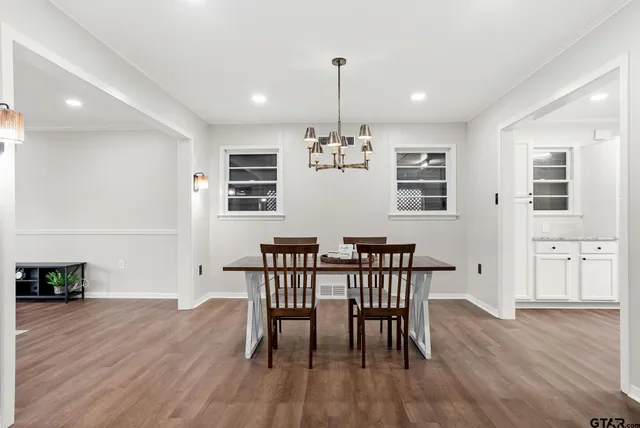 a view of a dining room with furniture wooden floor and chandelier
