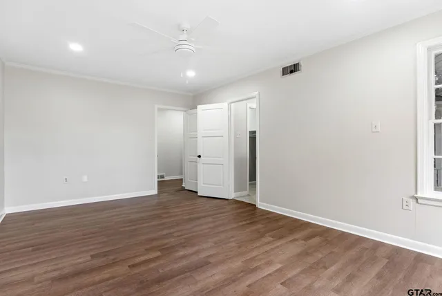 a view of an empty room with wooden floor