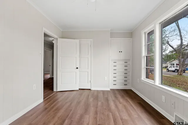 a view of empty room with wooden floor and windows