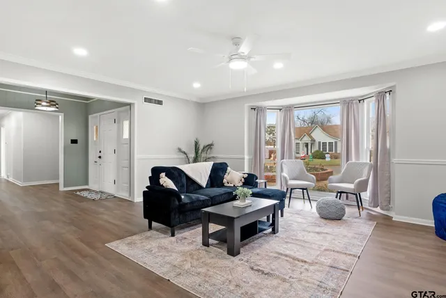a living room with furniture and wooden floor