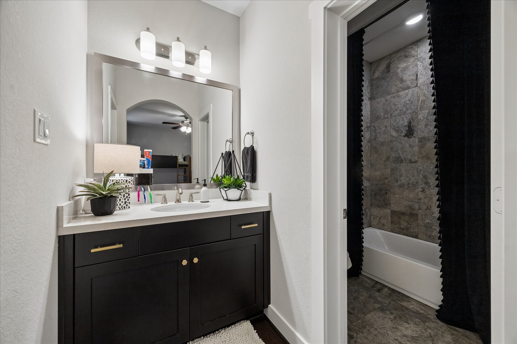 2416 Couch Street Houston, TX 77008 - Photo 13 of 34 a bathroom with a sink a mirror and a bathtub
