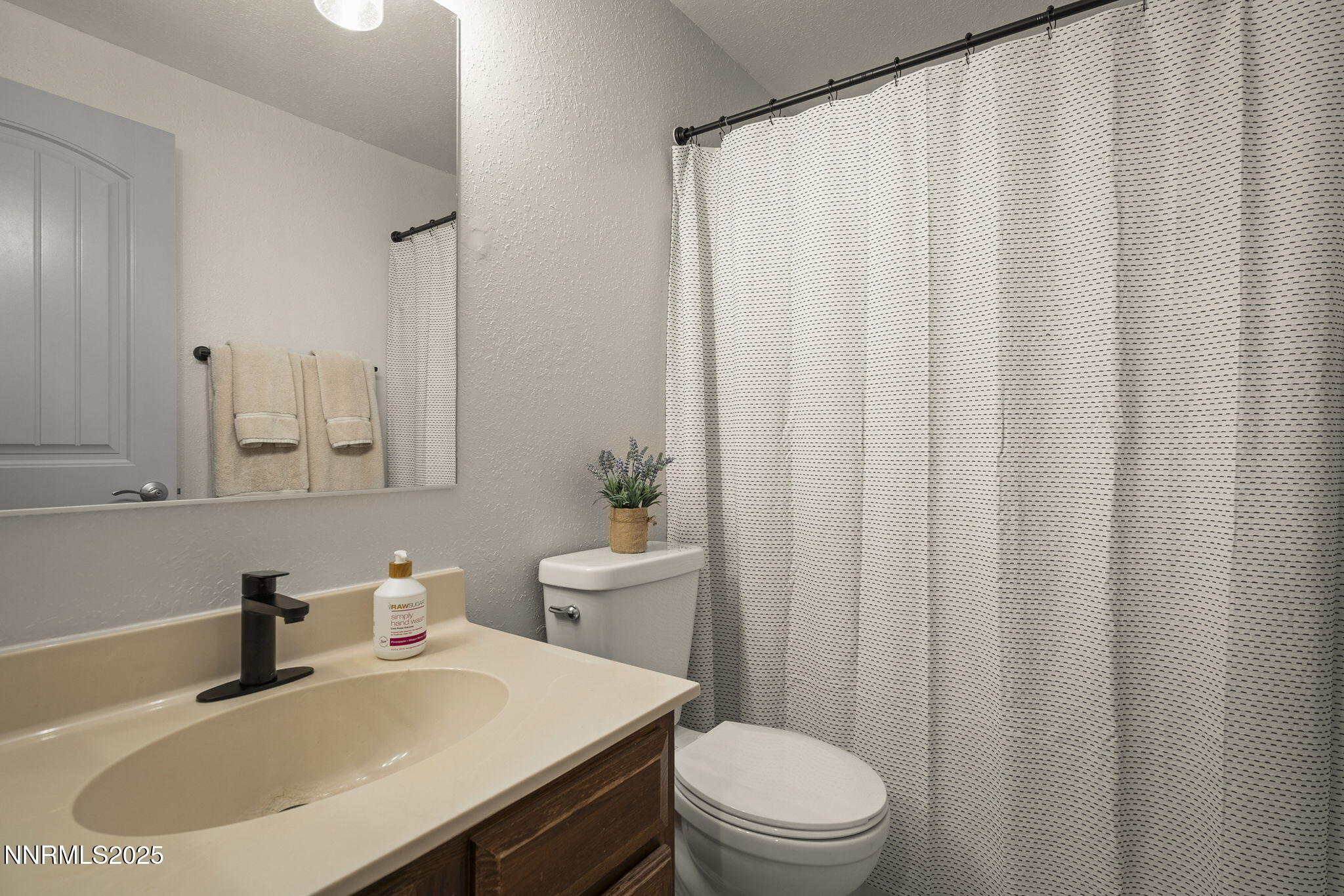 1080 Tudor Court Reno, NV 89503 - Photo 20 of 30 a bathroom with a sink a toilet and shower curtain