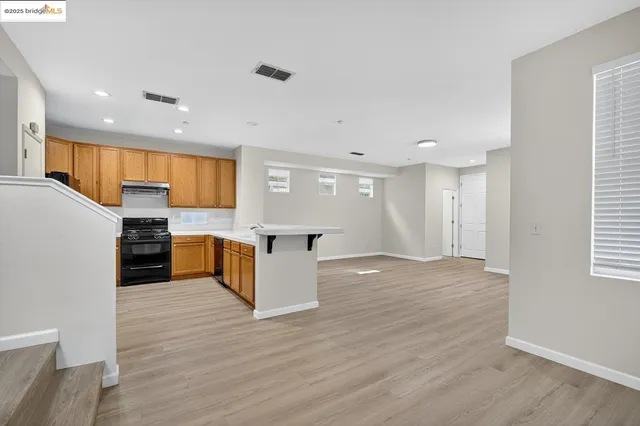 a large kitchen with a center island and wooden floor