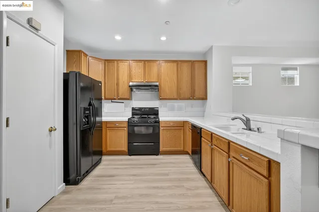 a kitchen with a refrigerator sink and wooden cabinets