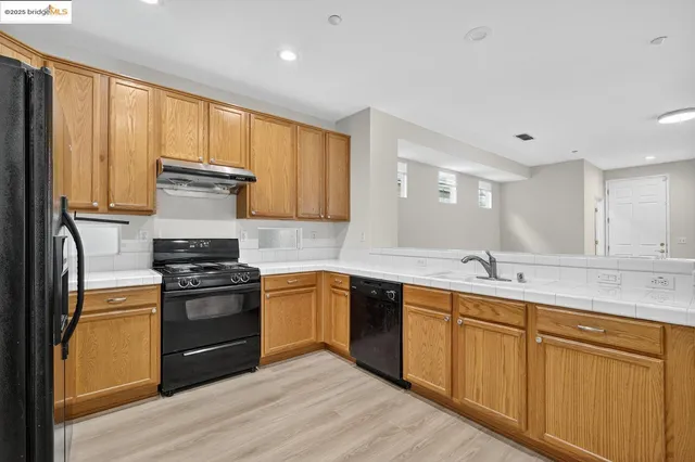 a kitchen with stainless steel appliances granite countertop a stove sink and cabinets
