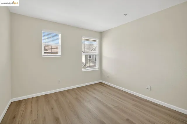 a view of a room with wooden floor and windows